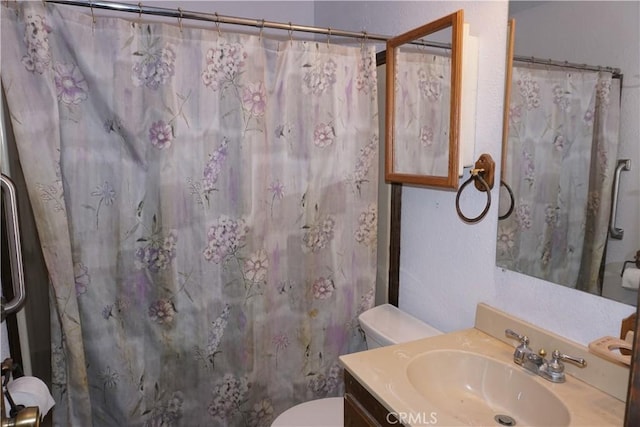 bathroom with a shower with curtain, toilet, and vanity