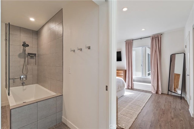 bathroom featuring hardwood / wood-style flooring and tiled shower / bath