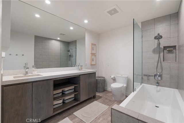 full bathroom with vanity, toilet, tiled shower / bath combo, and hardwood / wood-style flooring