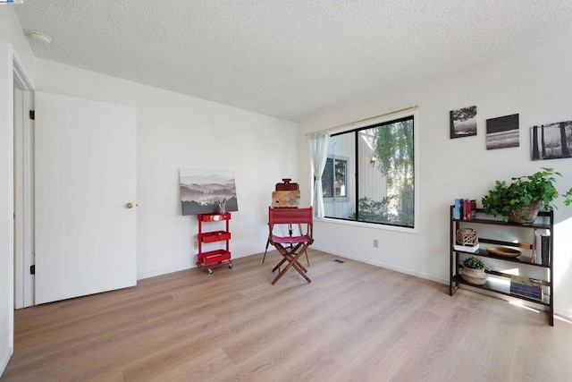 sitting room featuring light hardwood / wood-style floors and a textured ceiling