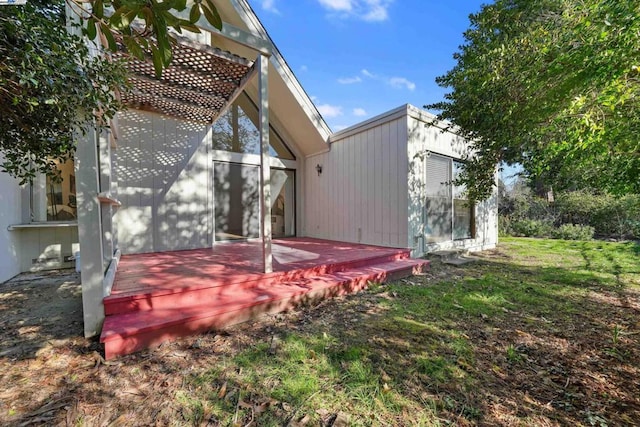 exterior space with a wooden deck and a lawn