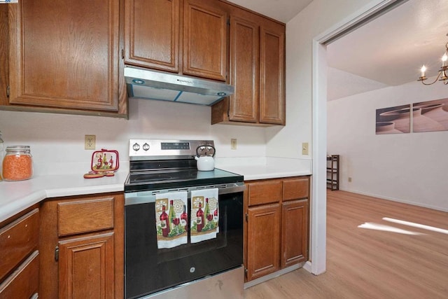 kitchen featuring a chandelier, stainless steel electric range, and light wood-type flooring