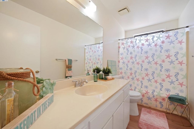 full bathroom with vanity, shower / tub combo, hardwood / wood-style flooring, and toilet