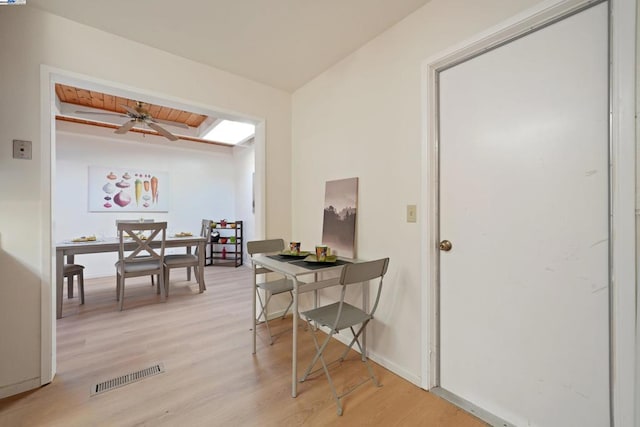 dining room featuring wood ceiling, ceiling fan, lofted ceiling with beams, and light hardwood / wood-style flooring