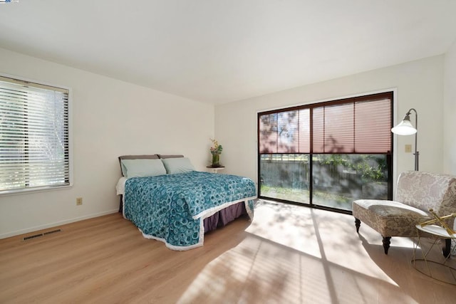 bedroom featuring access to exterior and hardwood / wood-style flooring