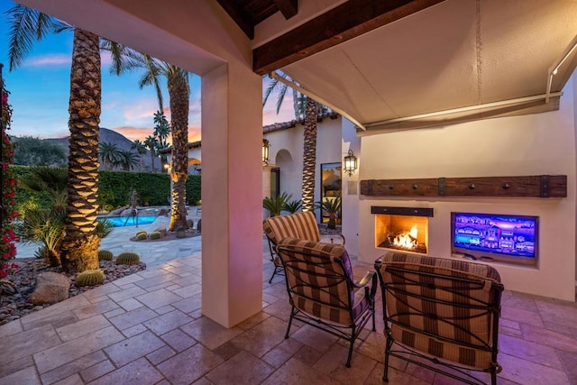 patio terrace at dusk with an outdoor fireplace