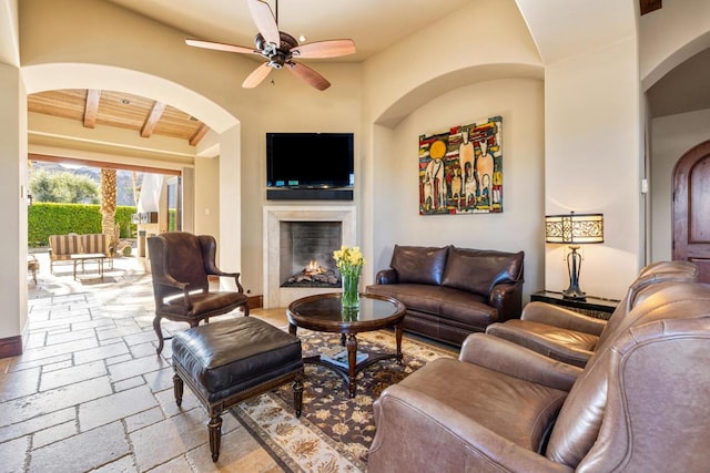 living room featuring wood ceiling, ceiling fan, and beam ceiling