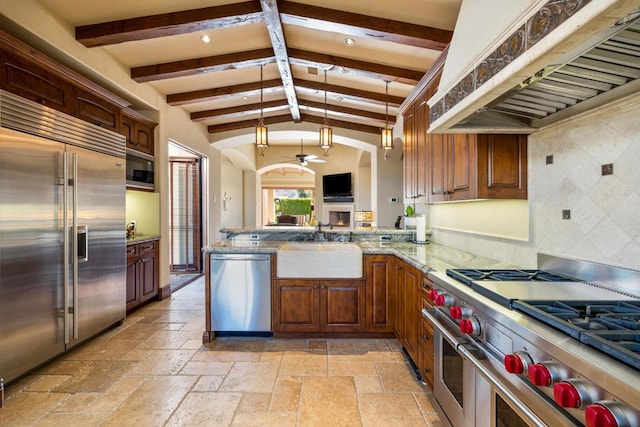 kitchen with custom exhaust hood, lofted ceiling with beams, kitchen peninsula, and built in appliances