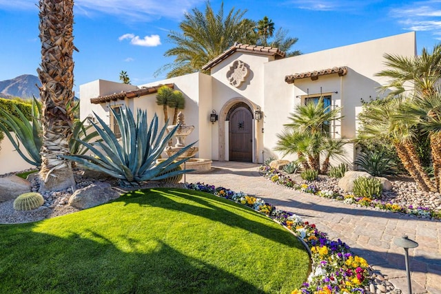 mediterranean / spanish house with a front yard