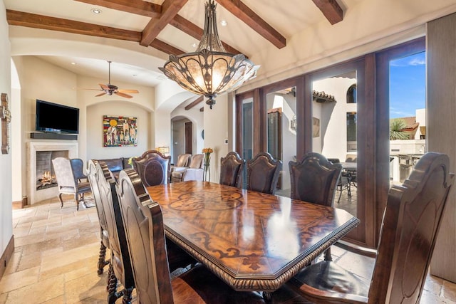 dining space with ceiling fan with notable chandelier and vaulted ceiling with beams