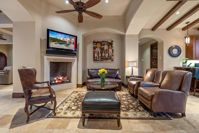 living room featuring beamed ceiling and ceiling fan