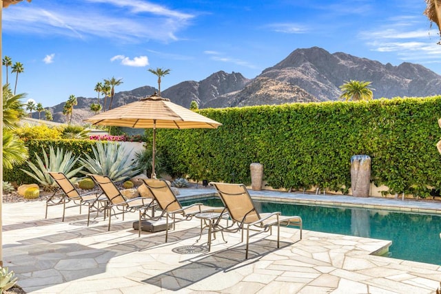 view of swimming pool with a mountain view and a patio