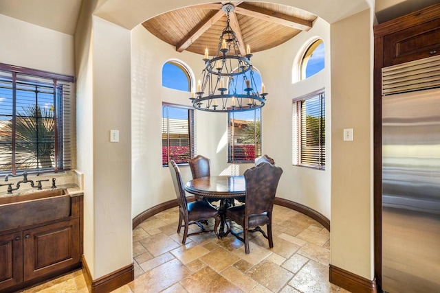 dining room with sink, a chandelier, beamed ceiling, and wood ceiling