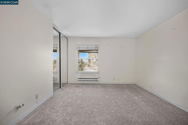 unfurnished room featuring a baseboard radiator and carpet floors