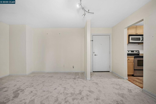 carpeted spare room featuring track lighting