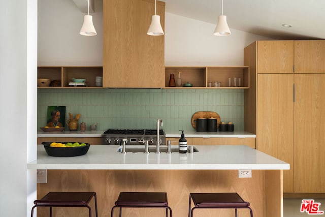 kitchen featuring a kitchen bar, vaulted ceiling, kitchen peninsula, pendant lighting, and backsplash