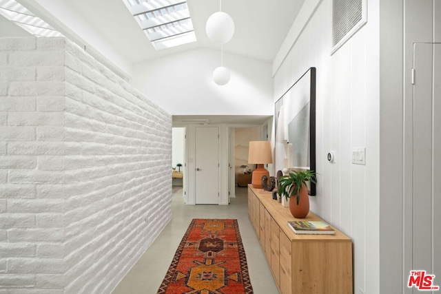 hallway featuring vaulted ceiling with skylight