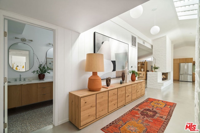 hallway with sink and lofted ceiling