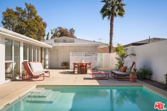 view of swimming pool with a patio area and exterior bar