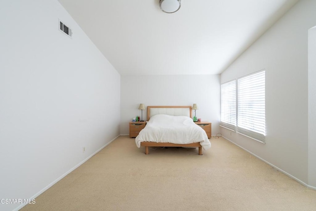 carpeted bedroom with lofted ceiling