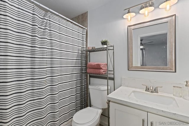 bathroom featuring ceiling fan, toilet, a shower with shower curtain, and vanity