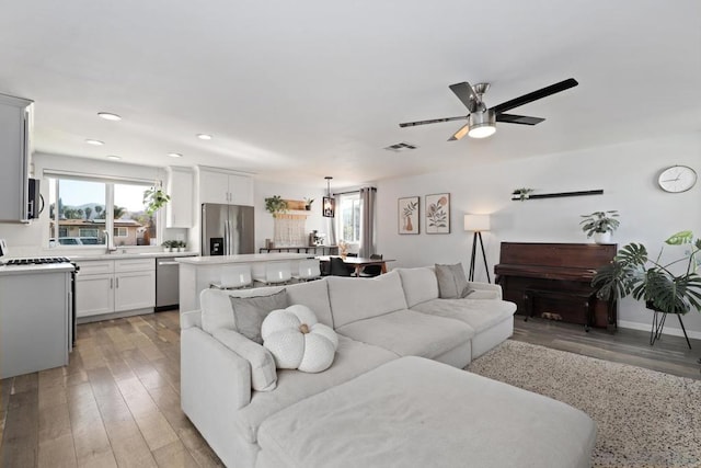 living room featuring ceiling fan and light hardwood / wood-style flooring