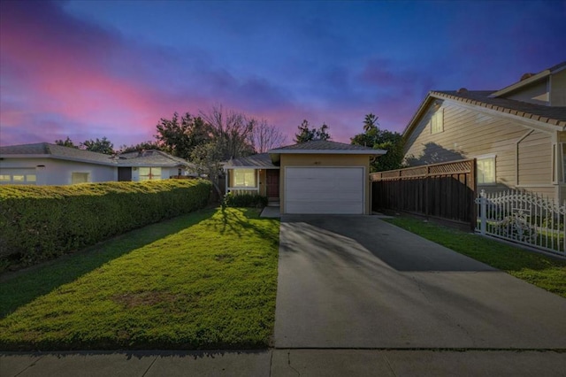 view of front of property featuring a garage and a lawn