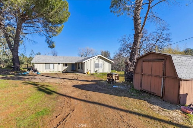 view of front facade with a front yard and a storage shed