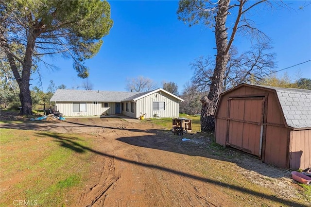 view of front of property with a shed, an outdoor structure, and a front yard