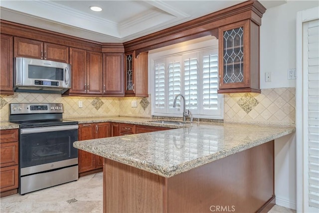 kitchen featuring crown molding, appliances with stainless steel finishes, sink, kitchen peninsula, and light stone counters