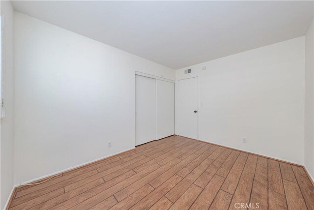 unfurnished room with light wood-type flooring