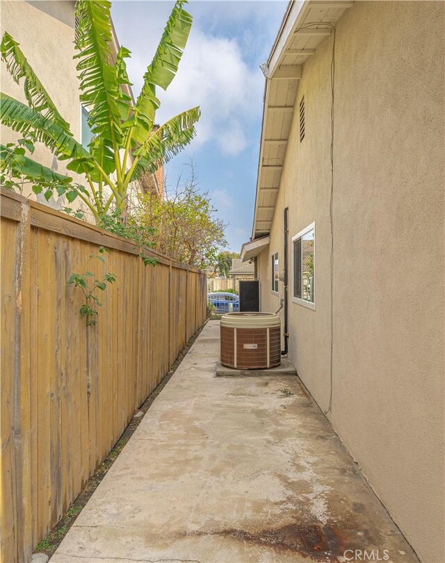 view of side of property with a patio and central AC unit