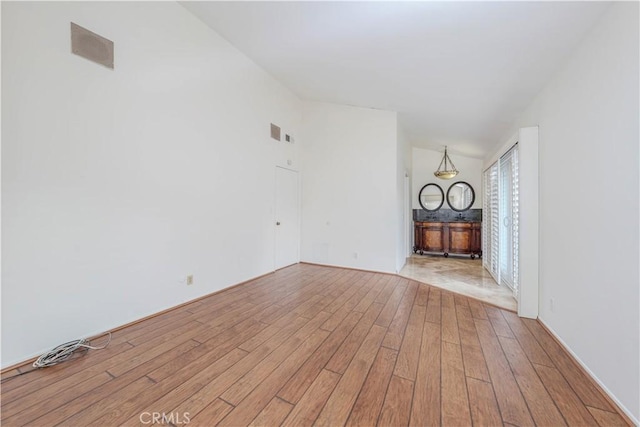 unfurnished living room featuring light hardwood / wood-style floors and vaulted ceiling