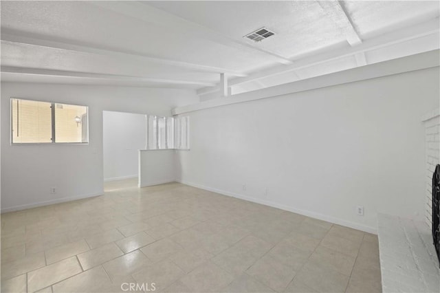 empty room featuring vaulted ceiling with beams, light tile patterned floors, and a fireplace