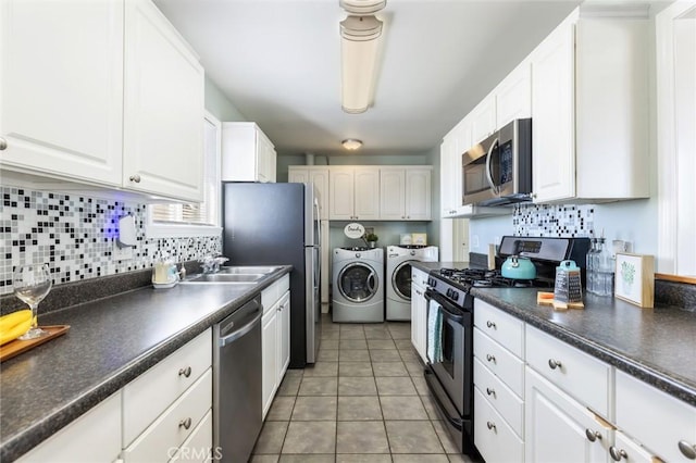 kitchen featuring separate washer and dryer, white cabinets, appliances with stainless steel finishes, backsplash, and light tile patterned floors