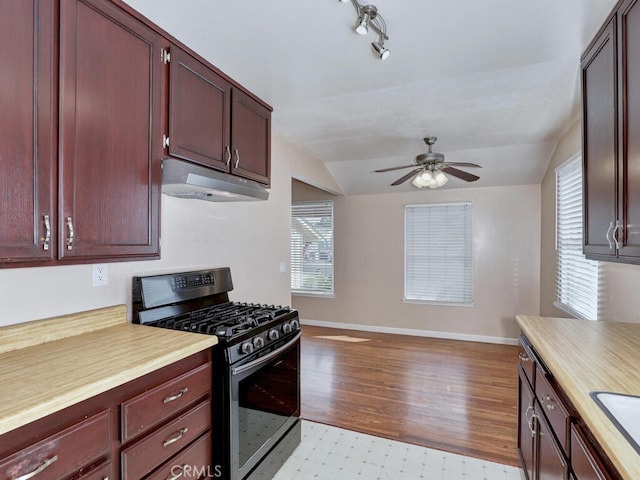 kitchen with sink, vaulted ceiling, gas range, and ceiling fan