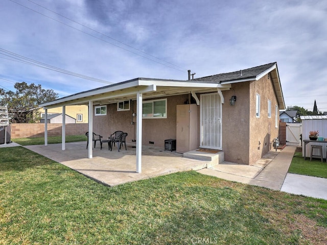 rear view of house with a patio area and a yard