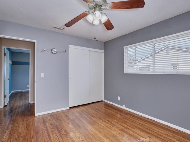 unfurnished bedroom with hardwood / wood-style floors, a closet, and ceiling fan