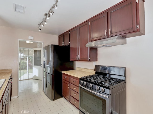 kitchen featuring black fridge and stainless steel gas range oven