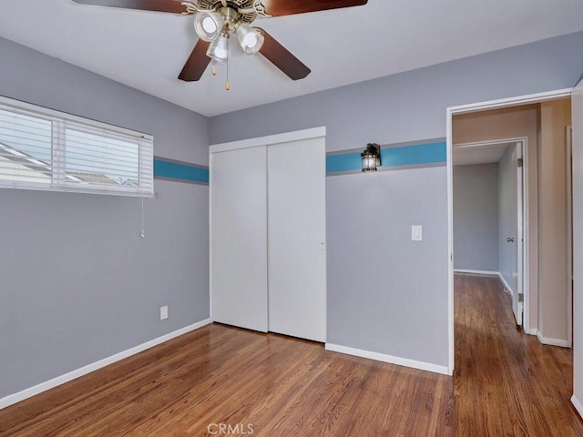 unfurnished bedroom with a closet, ceiling fan, and dark hardwood / wood-style flooring