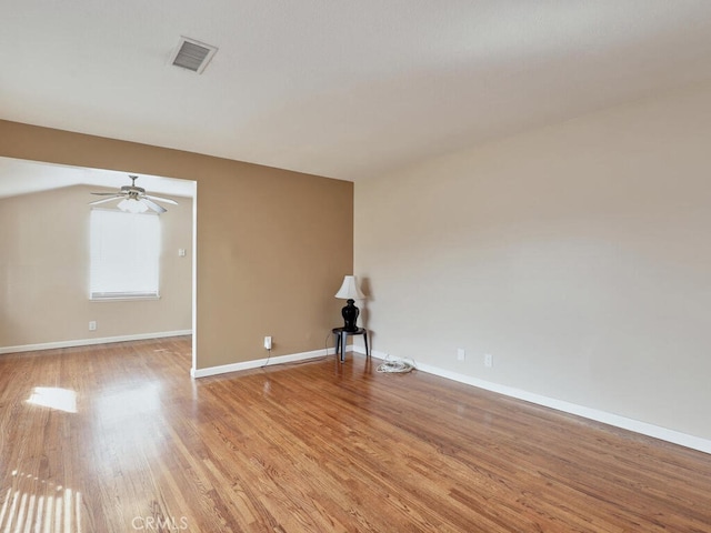 empty room with ceiling fan and light hardwood / wood-style flooring