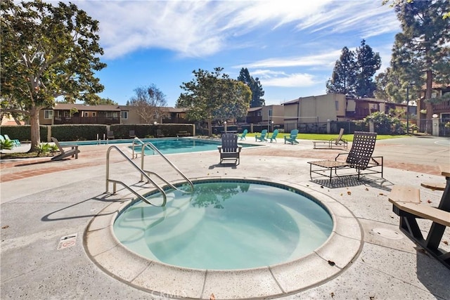 view of swimming pool featuring a patio area and a hot tub