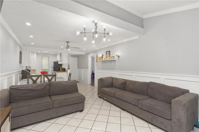 living room featuring ceiling fan with notable chandelier, light tile patterned floors, and crown molding