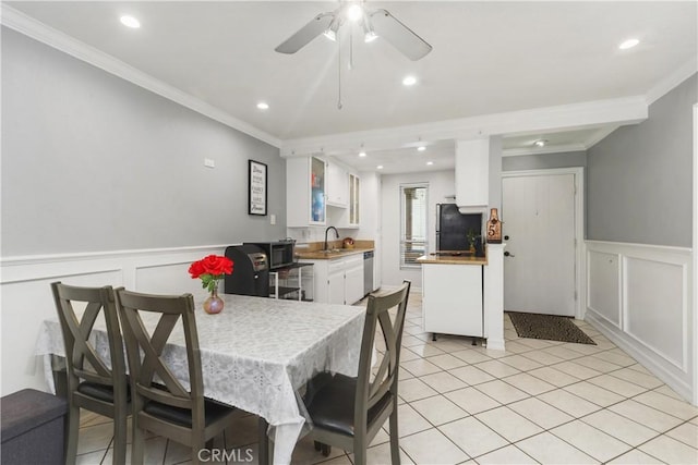 dining area with sink, ornamental molding, light tile patterned flooring, and ceiling fan