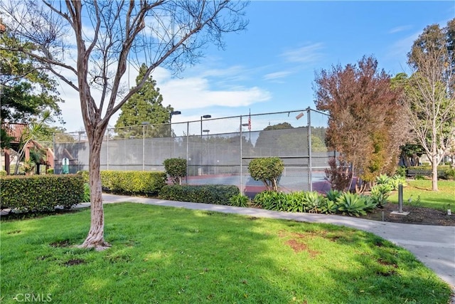 view of property's community featuring a yard and tennis court