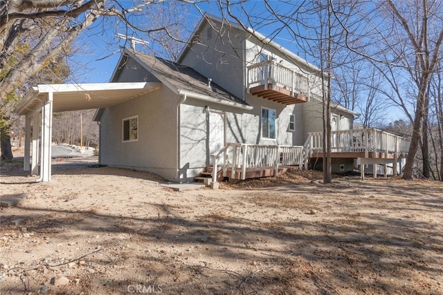 back of house with a balcony and a deck