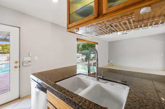 kitchen featuring sink, dishwasher, and light tile patterned flooring