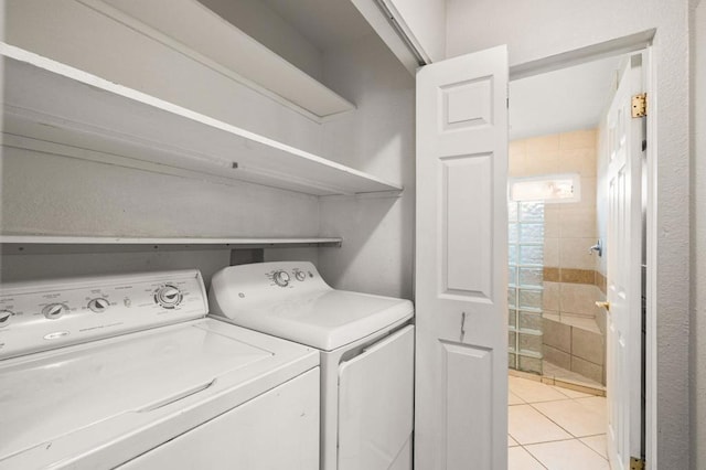 clothes washing area featuring washing machine and dryer and light tile patterned floors