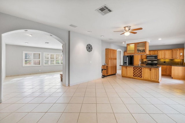 kitchen with light tile patterned flooring, backsplash, ceiling fan, and stainless steel appliances