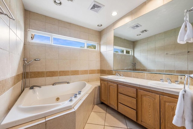 bathroom featuring tile patterned flooring, vanity, a healthy amount of sunlight, tile walls, and independent shower and bath